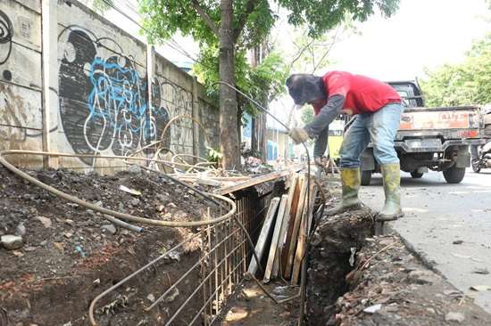 Petugas membersihkan saluran pada publikasi drainase Bandung, 29 Januari 2026.